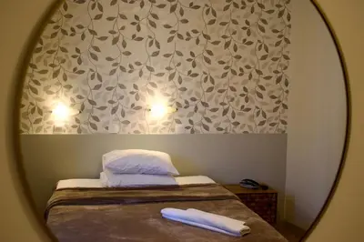 a mirror reflection of a bed with two pillows at Nafsika Hotel Athens Centre in Athens