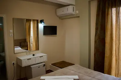 a bedroom with a bed and a sink and a mirror at Nafsika Hotel Athens Centre in Athens