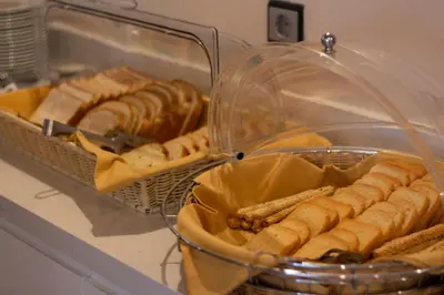 a bunch of hot dogs and pastries in a bakery at Anemoni Piraeus Hotel in Piraeus