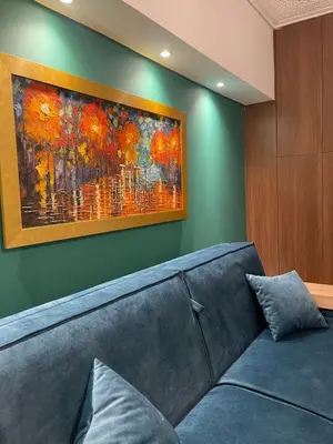 a couch in a room with a painting on the wall at Cute tiny apartment in the heart of Flisvos in Athens