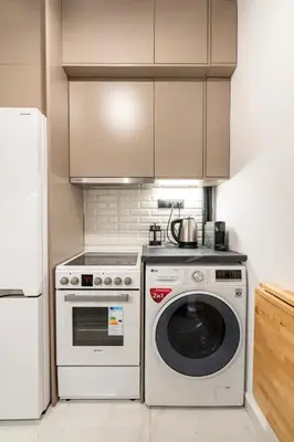 a kitchen with a washing machine and a refrigerator at Cute tiny apartment in the heart of Flisvos in Athens
