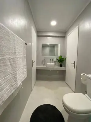 a white bathroom with a toilet and a sink at Sea Urban 4 Varkiza in Vari
