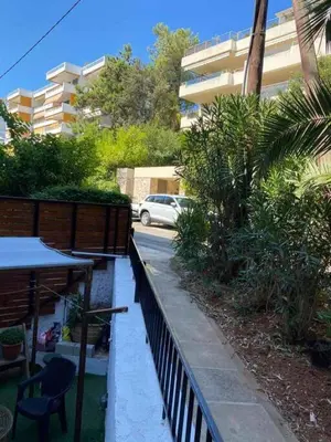 a balcony with a table and chairs and a building at Sea Urban 4 Varkiza in Vari