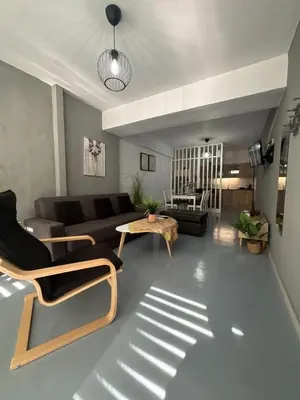 a living room with a couch and a table at Sea Urban 4 Varkiza in Vari