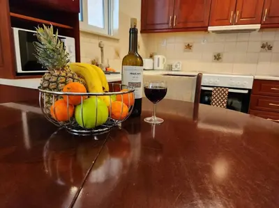 a bowl of fruit and a glass of wine on a kitchen counter at Comfy Place In Panteleymon VIPGreece in Athens