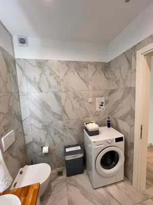a bathroom with a washing machine and a toilet at Casa de Tres Hermanos in the heart of Athens in Athens