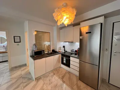 a kitchen with a stainless steel refrigerator and a chandelier at Casa de Tres Hermanos in the heart of Athens in Athens