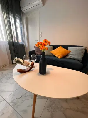a living room with a table with a vase of flowers at Casa de Tres Hermanos in the heart of Athens in Athens