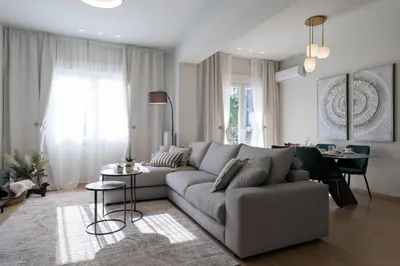 a living room with a gray couch and a table at Acropolis Deluxe 2BR Apartment in Athens