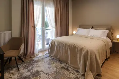 a bedroom with a bed and a large window at Acropolis Deluxe 2BR Apartment in Athens