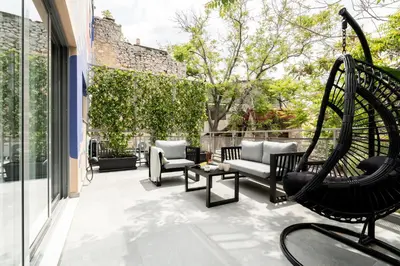 an outdoor patio with a swing and chairs at Play Psyri Athens a member of Brown Hotels in Athens