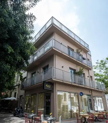 a building with tables and chairs in front of it at Play Psyri Athens a member of Brown Hotels in Athens