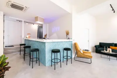 a living room with a bar with stools at Play Psyri Athens a member of Brown Hotels in Athens