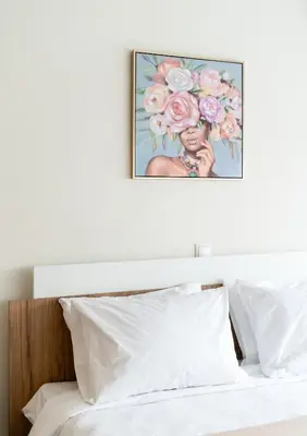 a picture of a woman with flowers above a bed at Elysee apatment 9A in Athens