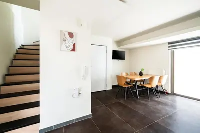 a dining room with a table and chairs and a staircase at Elysee apatment 9A in Athens