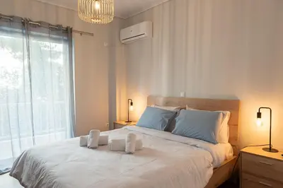 a bedroom with a large bed with two towels on it at Twins apartments - Concert Hall in Athens