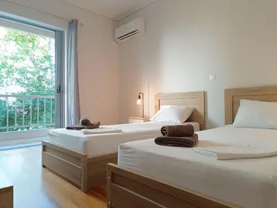 two beds in a room with a window at Twins apartments - Concert Hall in Athens