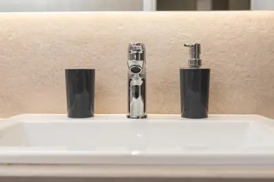 a sink with a faucet and two cups on it at Twins apartments - Concert Hall in Athens