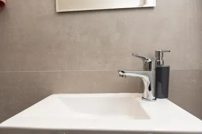 a sink with a faucet in a bathroom at Twins apartments - Concert Hall in Athens