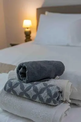 a pile of towels sitting on top of a bed at Αlpha- Αthenian apartments in Athens