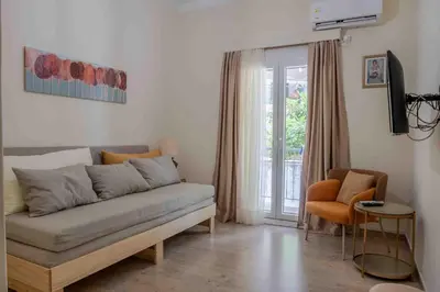 a living room with a couch and a window at Αlpha- Αthenian apartments in Athens