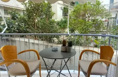 a table and chairs on a balcony with trees at Αlpha- Αthenian apartments in Athens