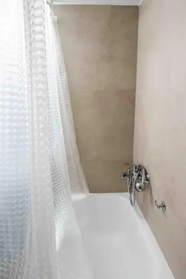 a bathroom with a white shower curtain and a tub at Αlpha- Αthenian apartments in Athens