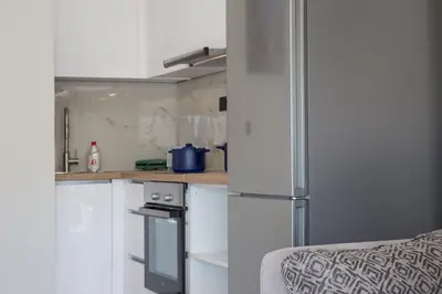 a kitchen with white cabinets and a refrigerator at Unforgettable Acropolis View in Athens