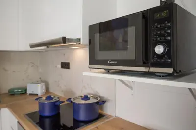 a kitchen with a microwave and three blue pots at Unforgettable Acropolis View in Athens