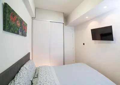 a bedroom with a bed and a flat screen tv at Unforgettable Acropolis View in Athens