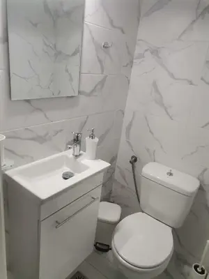 a white bathroom with a toilet and a sink at S & K Apartment free indoor parking in Athens