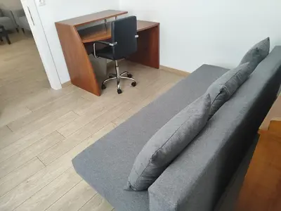 a couch with pillows on it in a room with a desk at S & K Apartment free indoor parking in Athens