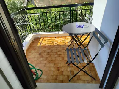 a small table and chair on a balcony at S & K Apartment free indoor parking in Athens