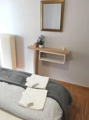 a bedroom with a bed with a mirror on the wall at Roulas house Διαμέρισμα Κέντρο Σεπόλια ΜΕΤΡΟ in Athens