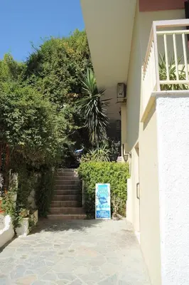 a stairway leading up to a house with a sign at The Delfini Hotel in Agia Marina Aegina