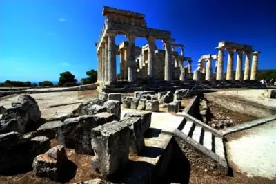 an ancient temple with columns in a field at The Delfini Hotel in Agia Marina Aegina