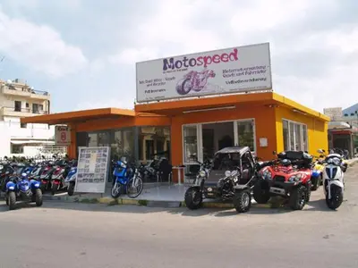 a store with a bunch of motorcycles parked in front of it at The Delfini Hotel in Agia Marina Aegina
