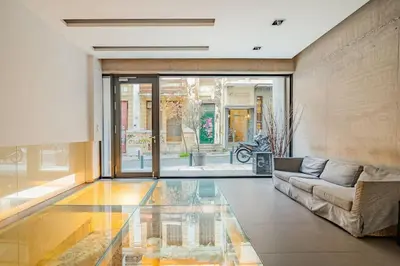 a living room with a couch and a glass floor at Modern Loft Build on Acropolis Ruins in Athens