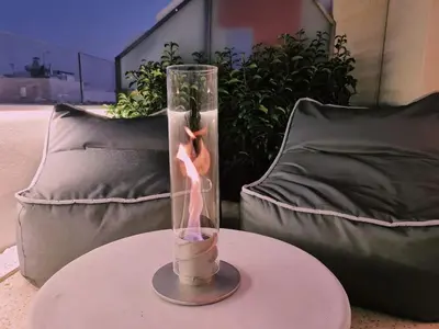 a glass vase sitting on a table in front of a couch at Heated Plunge Pool & Firepit Acropolis Penthouse in Athens