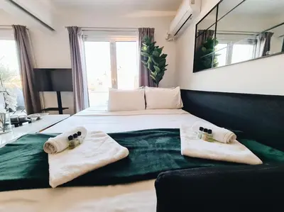 a bedroom with a large bed with towels on it at Heated Plunge Pool & Firepit Acropolis Penthouse in Athens