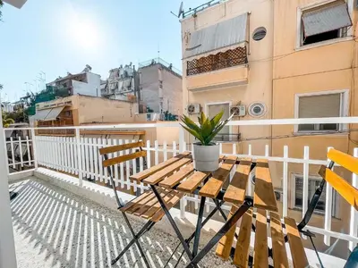 a wooden table and two chairs on a balcony at Luxury apartment close to metro & Akropolis- Cielo Homes in Athens