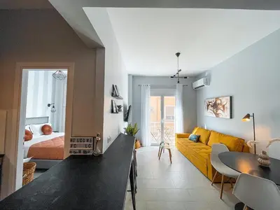 a living room with a yellow couch and a bed at Luxury apartment close to metro & Akropolis- Cielo Homes in Athens