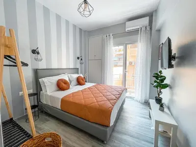 a bedroom with a bed with two orange pillows on it at Luxury apartment close to metro & Akropolis- Cielo Homes in Athens