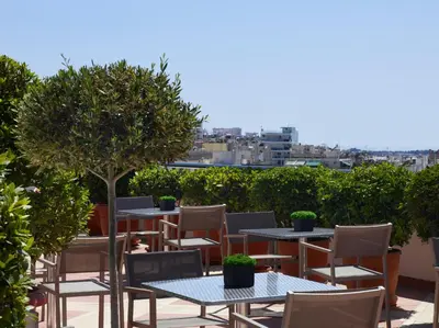 a row of tables and chairs on a roof at Athens Zafolia Hotel in Athens