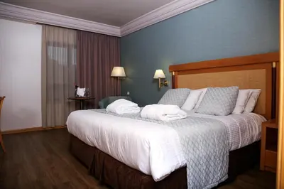a hotel room with a large bed with towels on it at Athens Zafolia Hotel in Athens