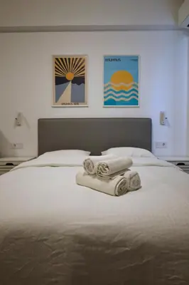 a bedroom with a bed with towels on it at Synathens II - Apartments & Studios in Athens