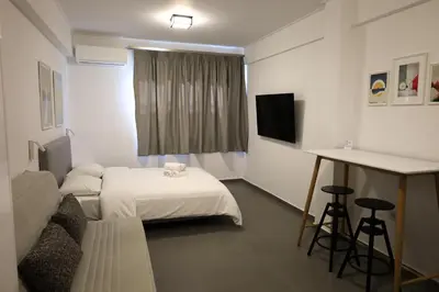 a hotel room with a bed and a table and a television at Synathens II - Apartments & Studios in Athens