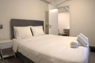 a bedroom with a large white bed with towels on it at Synathens II - Apartments & Studios in Athens