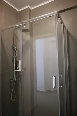 a shower with a glass door in a bathroom at Synathens II - Apartments & Studios in Athens