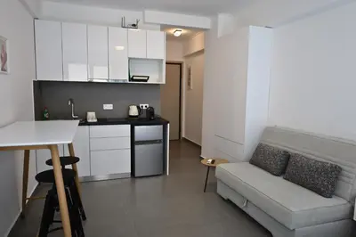 a living room with a couch and a kitchen at Synathens II - Apartments & Studios in Athens